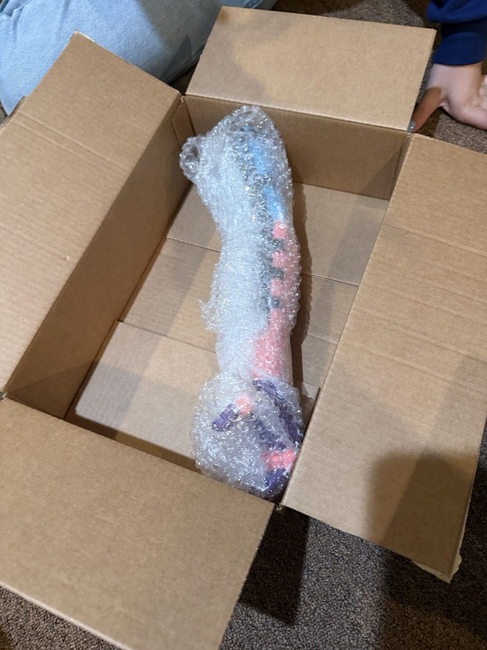 The finished arm wrapped in bubble wrap, nestled in a shipping box